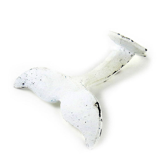Distressed white metal whale tail wall hook on a white background