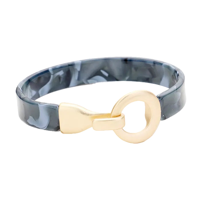 A grey celluloid acetate bracelet with a matte gold metal hook closure.