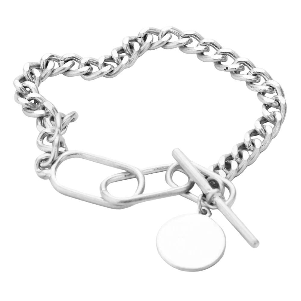 A silver chunky metal chain bracelet with a disc charm and a toggle closure.