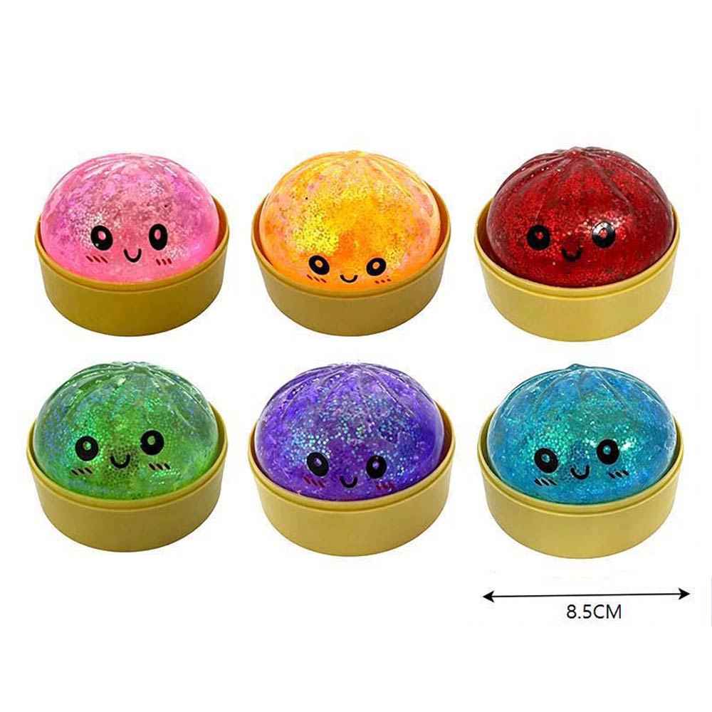 Set of six colorful glitter balls with smiling faces in yellow containers on a white background.