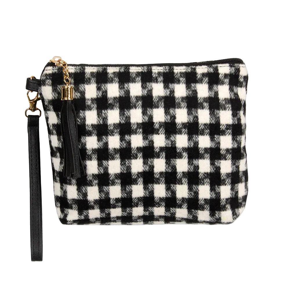 A black and white tasseled houndstooth clutch with a removable wristlet strap.