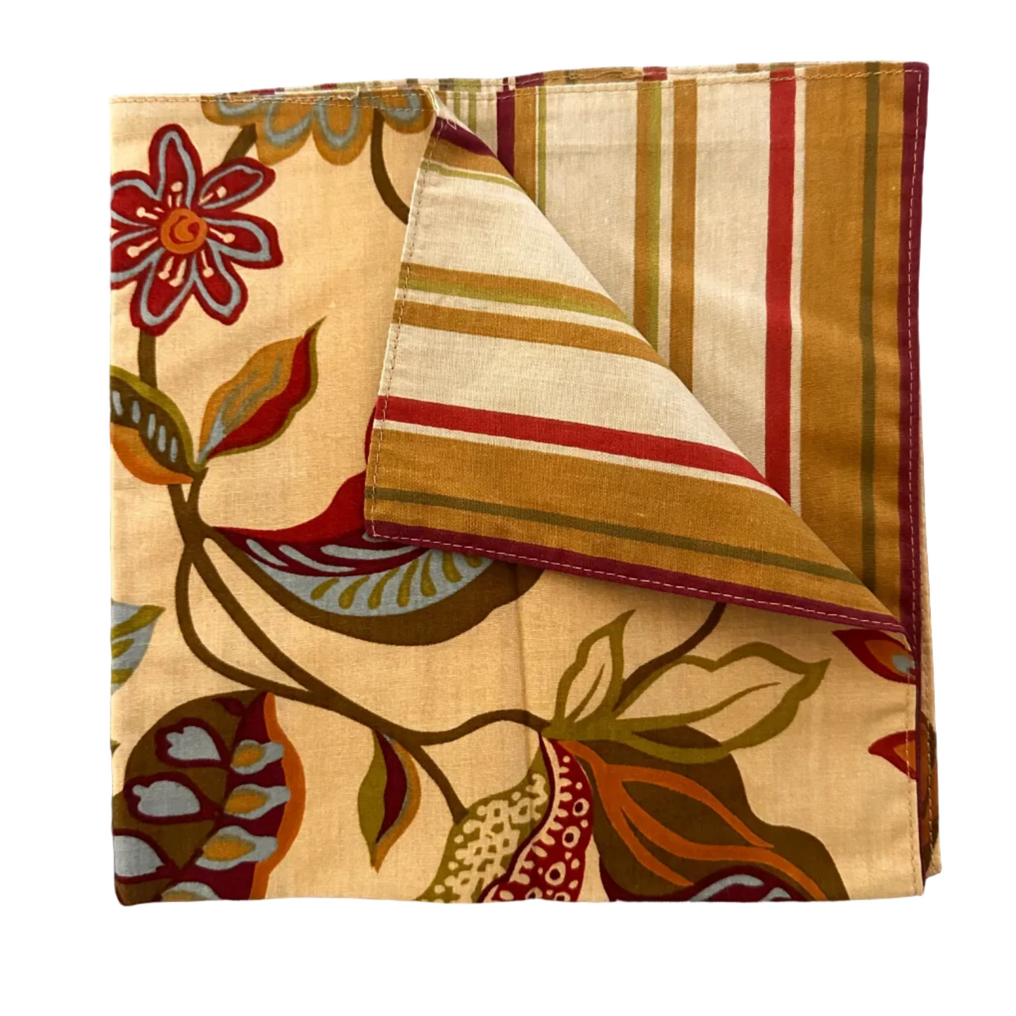 A folded square fabric napkin with a botanical and striped pattern, displayed on a gray wood-textured background.