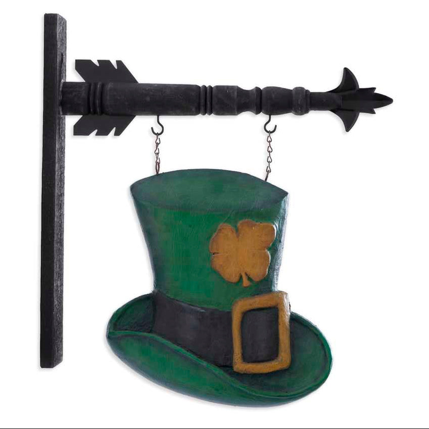 A wall decor sign featuring a green leprechaun hat with a clover on it, hanging from a black arrow bracket.