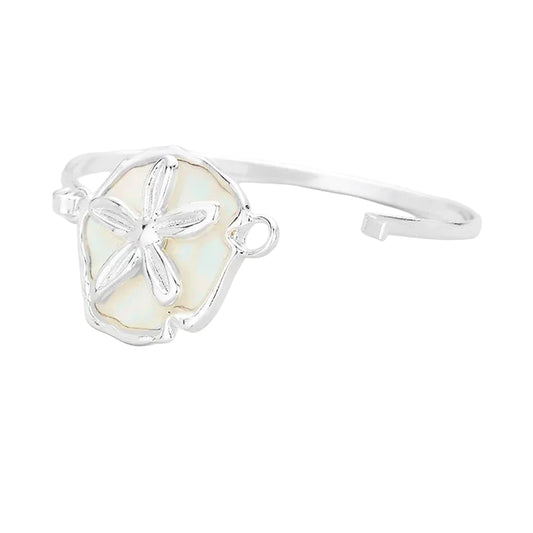 Silver bracelet with a sand dollar design on a white background