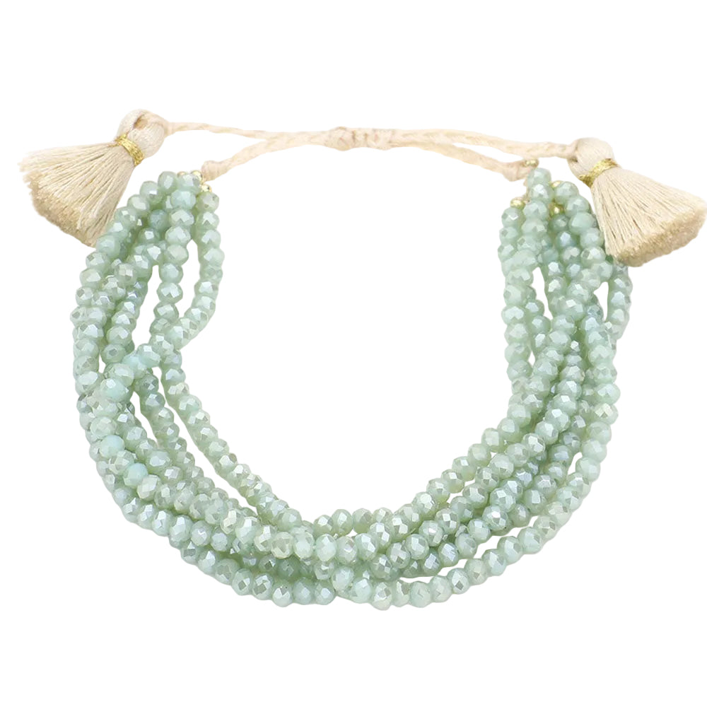 A multi-layered faceted beaded tassel cinch bracelet in mint and gold colors with adjustable tassels on a white background.