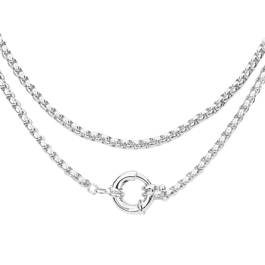 A double-layered silver chain necklace featuring a classic curb chain on the top layer and a thinner box chain on the bottom layer, finished with a polished circular ring clasp, shown against a plain white background.