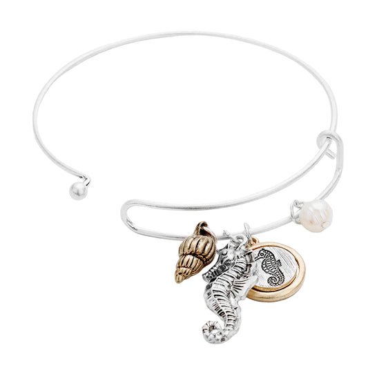 Silver bracelet with seashell, seahorse, and round charm on a white background