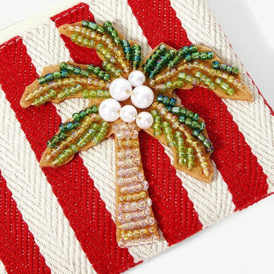 Red and white striped tropical coin purse featuring sparkling beaded palm tree with a red tassel, zipper closure and gold-tone keychain clip.