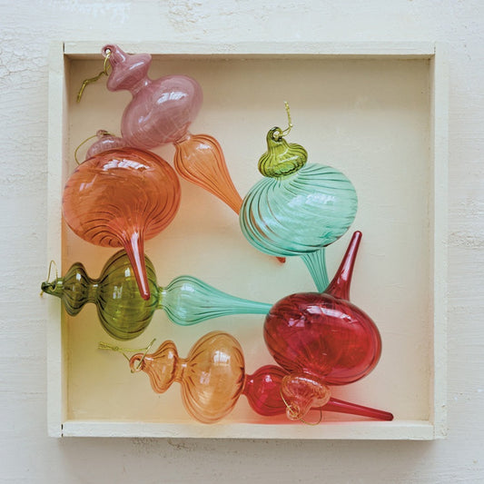 Colorful glass Christmas Tree Ornaments in a box on a light wooden surface