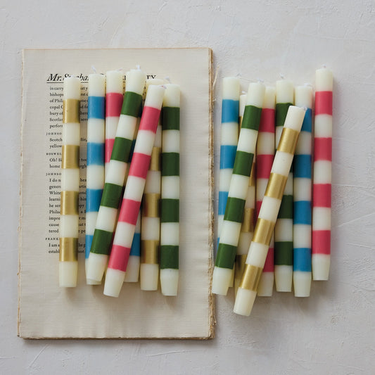 Colorful striped candles on an open book with a light background