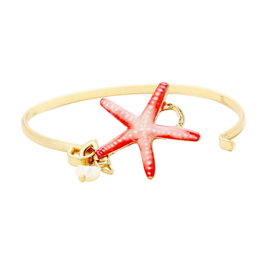 Gold bracelet with a coral colored starfish