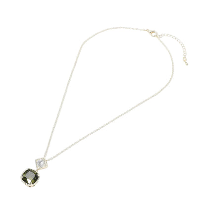 Necklace with a pendant featuring a green gemstone and clear crystal on a white background