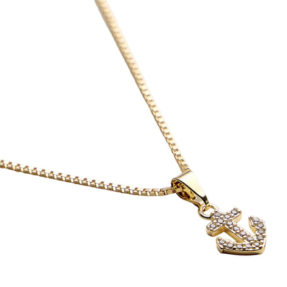 Gold anchor pendant necklace on a white background