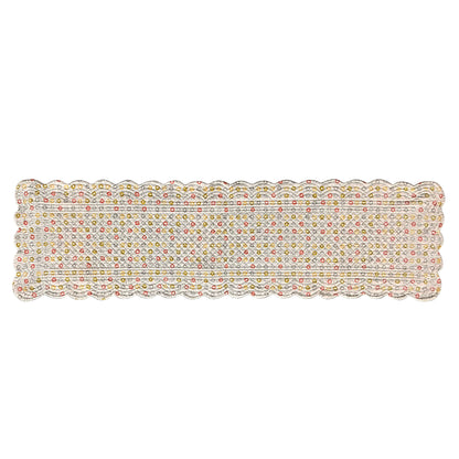A rectangular scalloped table runner with colorful polka dots a white background.