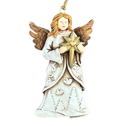 An angel Christmas ornament with a white gown, gold wings, and a gold star, resting on a white surface.