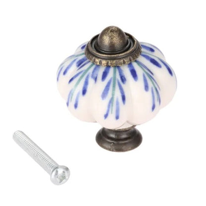 A blue and cream ceramic pumpkin-shaped cabinet knob with a metal screw for attachment.