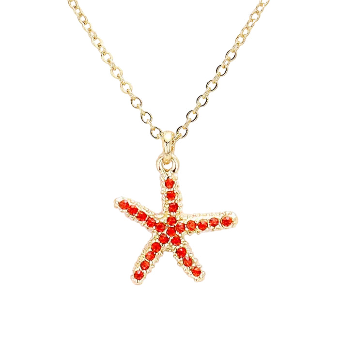 Gold necklace with a starfish pendant featuring red stones on a white background