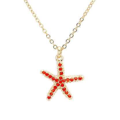 Gold necklace with a starfish pendant featuring red stones on a white background