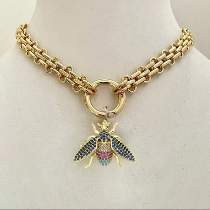 Gold chain necklace with a colorful bee pendant on a mannequin.