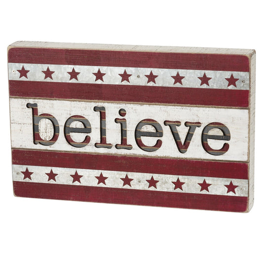 Wooden sign with 'believe' text and star patterns on a white background
