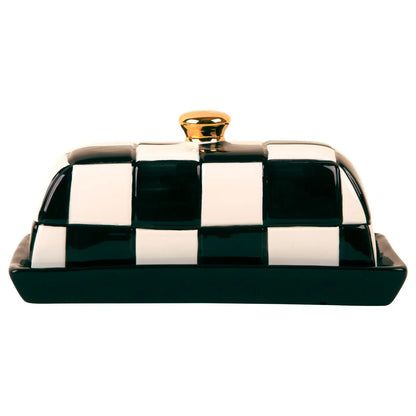 Black and white checkered ceramic butter dish with a solid black base and gold-tone knob. A playful, polished addition to the kitchen or table.