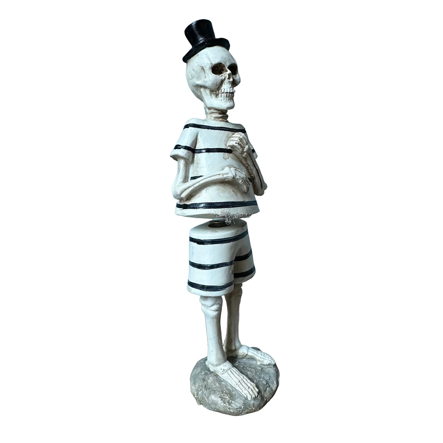 A decorative skeleton figurine dressed in a black-and-white striped outfit with a small black top hat, standing on a round base against a plain white background.