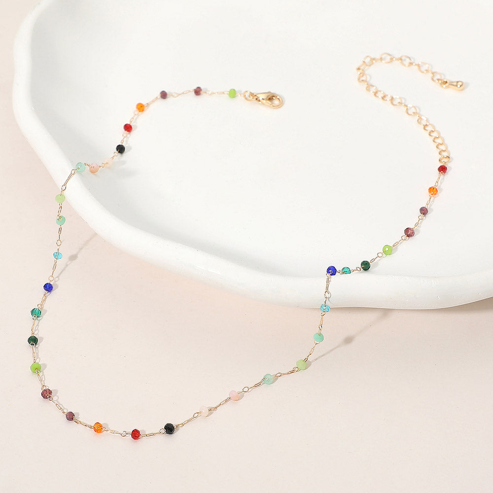 Necklace with multicolored beads on a white dish