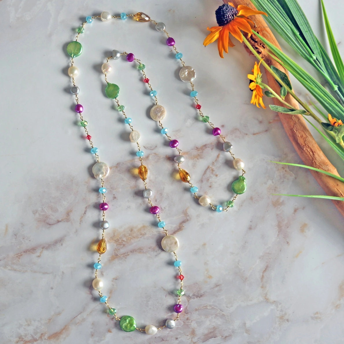 Long rosary-style necklace featuring cultured pearls and colorful crystals.