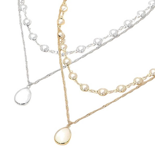 Two pearl necklaces in gold, silver, and ivory on a white background