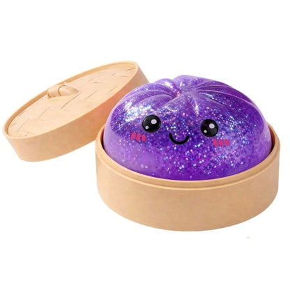 Purple glittery dumpling ball with a face in an open box on a white background
