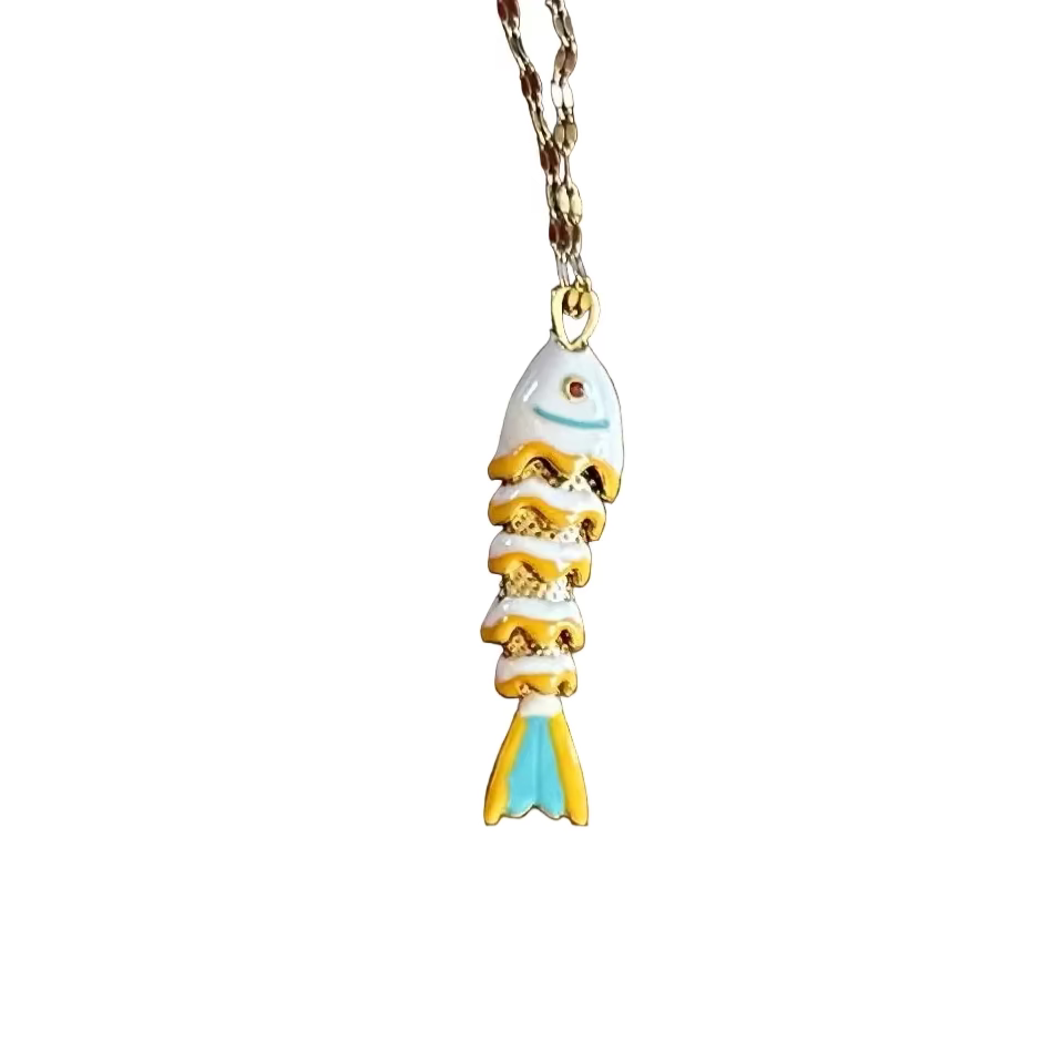 Small gold fish-shaped charm on a white background