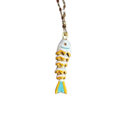 Small gold fish-shaped charm on a white background