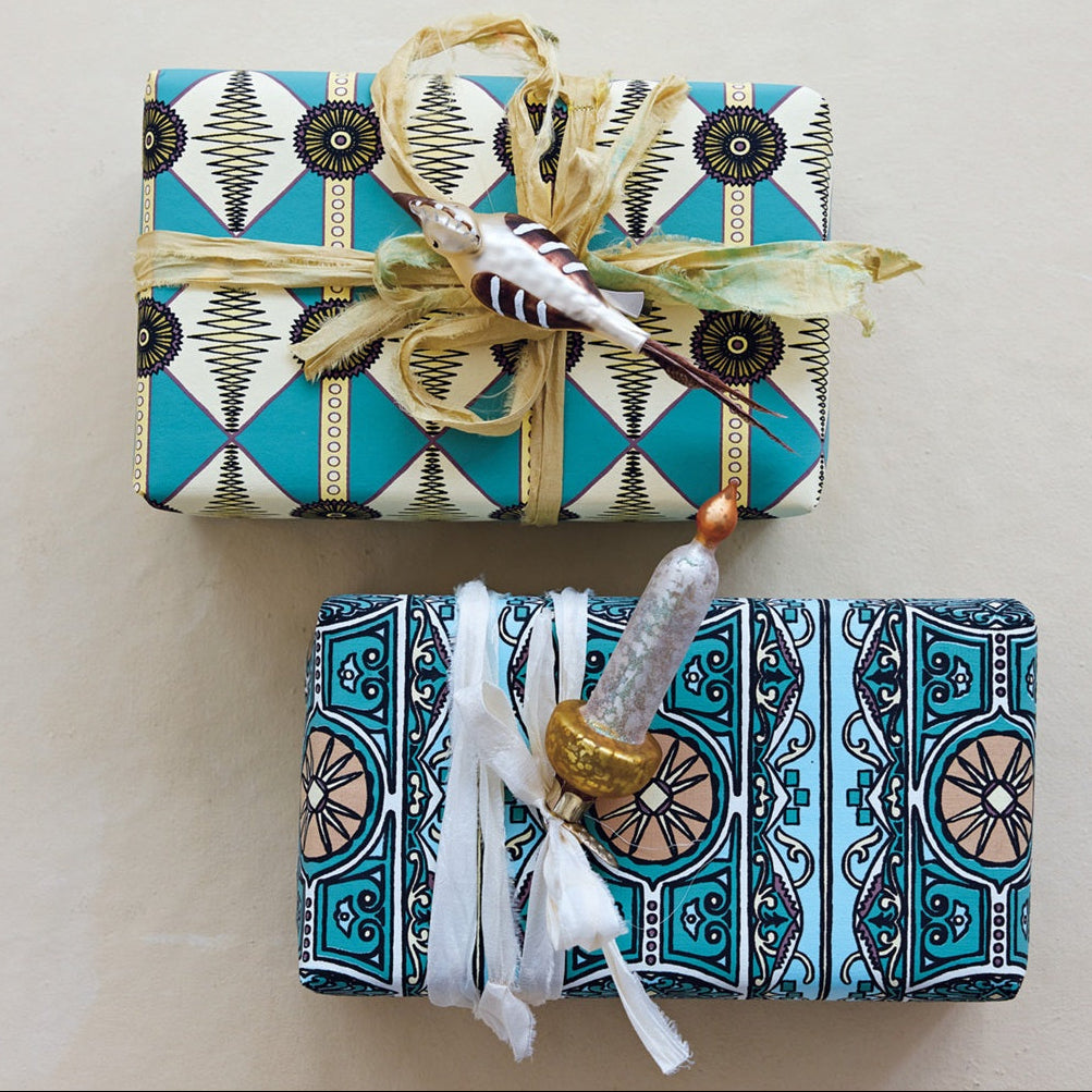 Two wrapped gifts with decorative ribbons on a light background