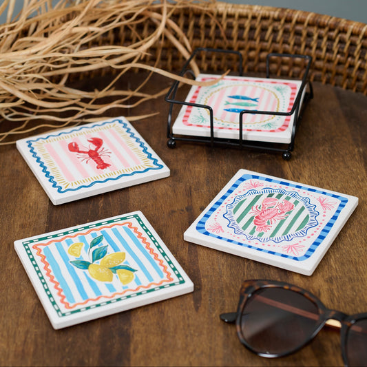 Set of decorative coasters with illustrations on a wooden surface with a wicker basket in the background.