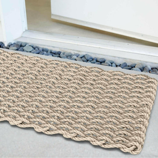 Textured beige doormat on a light gray floor with a white baseboard.