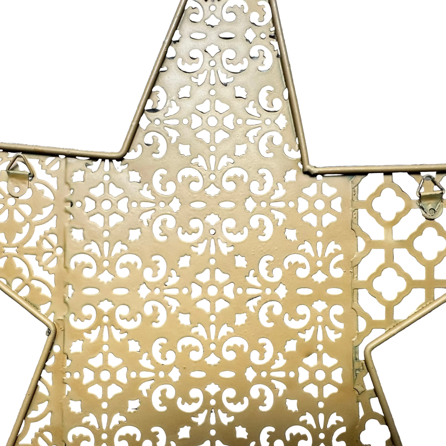 A close-up of a gold-toned metal star-shaped decorative piece with an intricate cutout filigree pattern, shown against a plain white background.