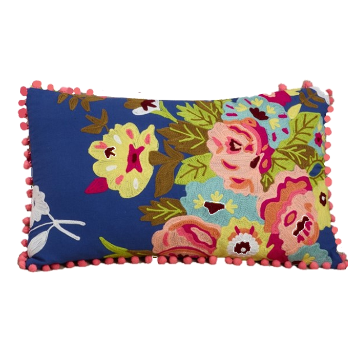 A rectangular decorative throw pillow with a vibrant floral pattern on a navy blue background, finished with pink pom-pom trim on all sides, shown against a plain white background.