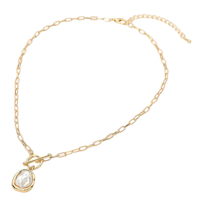 Gold necklace with a organic-shaped pearl pendant on a white background