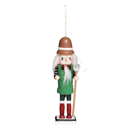 A small wooden farmer nutcracker holiday ornament with a brown hat, white beard, green tunic, and red boots, standing on a white background with a hanging loop at the top.