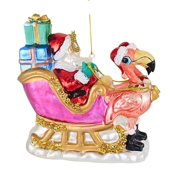 Pink Flamingo Sleigh with Santa glass Christmas ornament features Santa, colorful gifts, glitter and gold accents for a whimsical tropical holiday tree.
