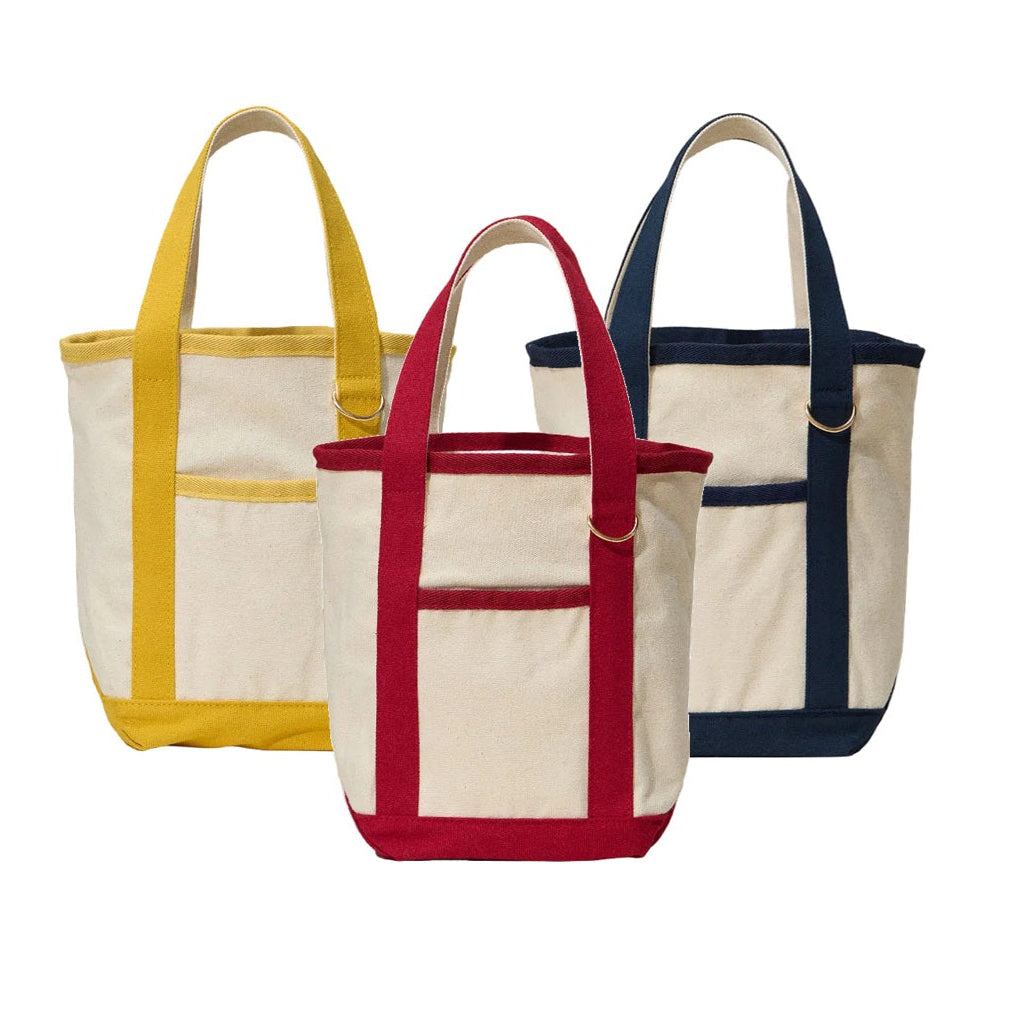 Three tote bags with yellow, red, and navy handles on a white background