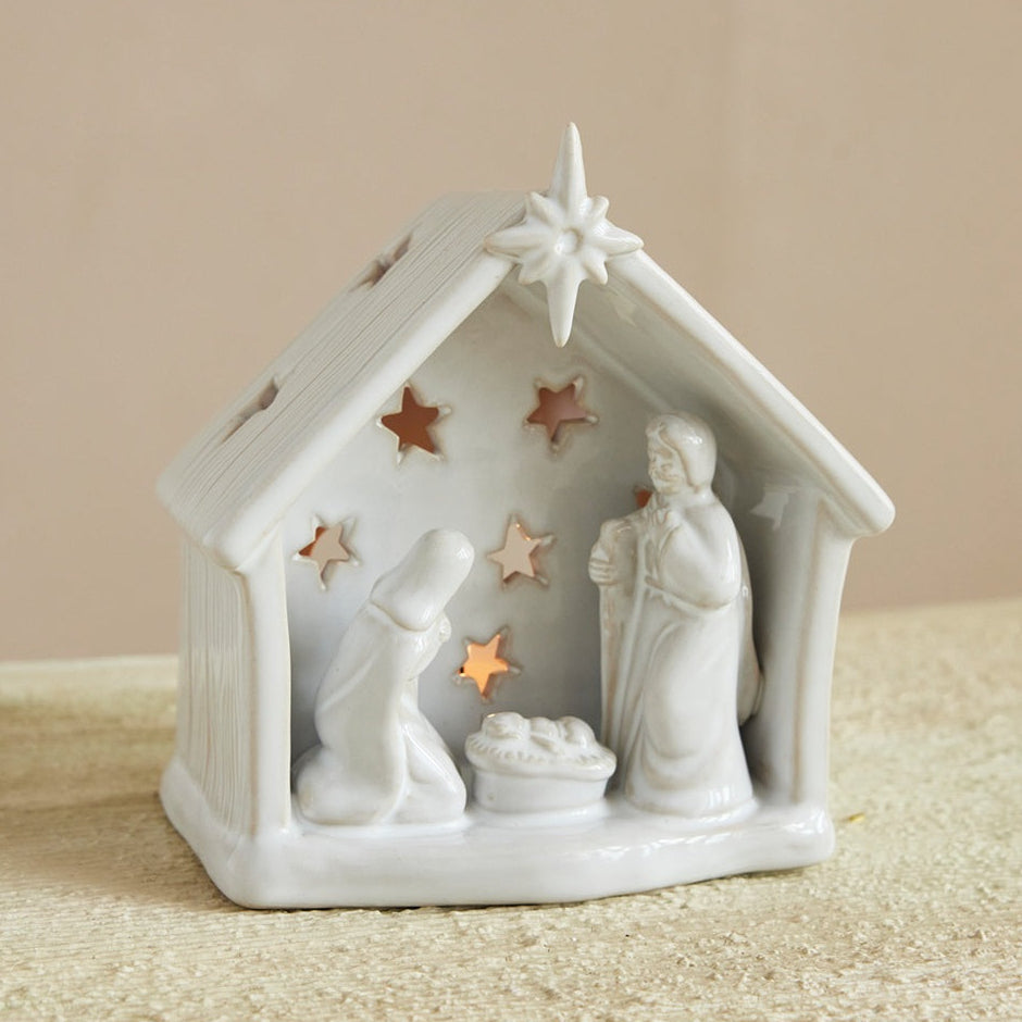 White nativity scene figurine with stars on a beige background