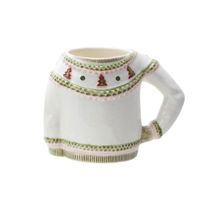 A white ceramic mug shaped like a long-sleeve sweater, featuring embroidered details in green, red, and white, set against a plain white background.