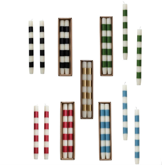 A collage-style product image showing multiple striped taper candles in different colorways, including black and white, green and white, red and white, and blue and white, arranged on a white background. 