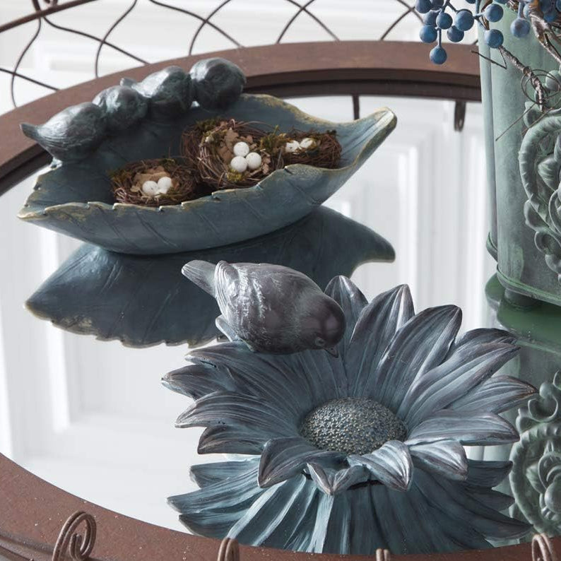 Charming sunflower bird feeder bowl in patina green with gold highlights. Features sculpted petals and a perched bird for whimsical garden décor.