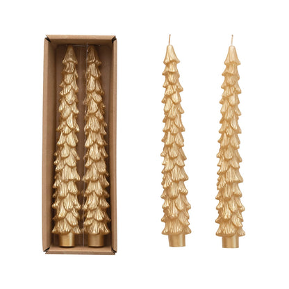A set of two gold-colored, tree-shaped taper candles, one displayed outside the box and the other inside, alongside a packaging box.