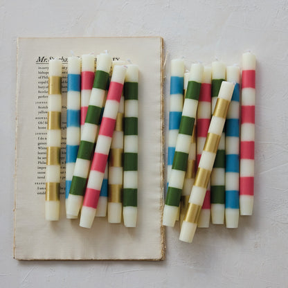Colorful striped candles on an open book with a light background
