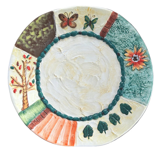 Decorative ceramic plate with nature-themed designs on a wooden surface