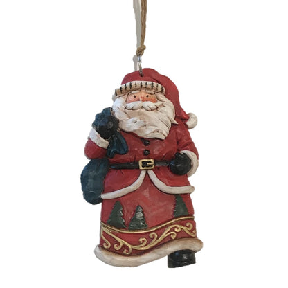 A carved look Christmas tree ornament of Santa Claus holding a sack, wearing a red and white outfit, with a simple twine string hanger.